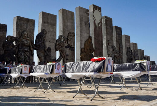 TOPSHOT - People attend a funeral ceremony for the remains of 41 victims from the Yazidi minority, who were executed by Islamic State (IS) group militants in 2014, in front of a memorial monument in Sinjar in northwestern Iraq's Nineveh province on January 24, 2024. The victims of the August 2014 massacre, carried out in the Sinjar region by IS group militants, have been recently identified through DNA tests.
